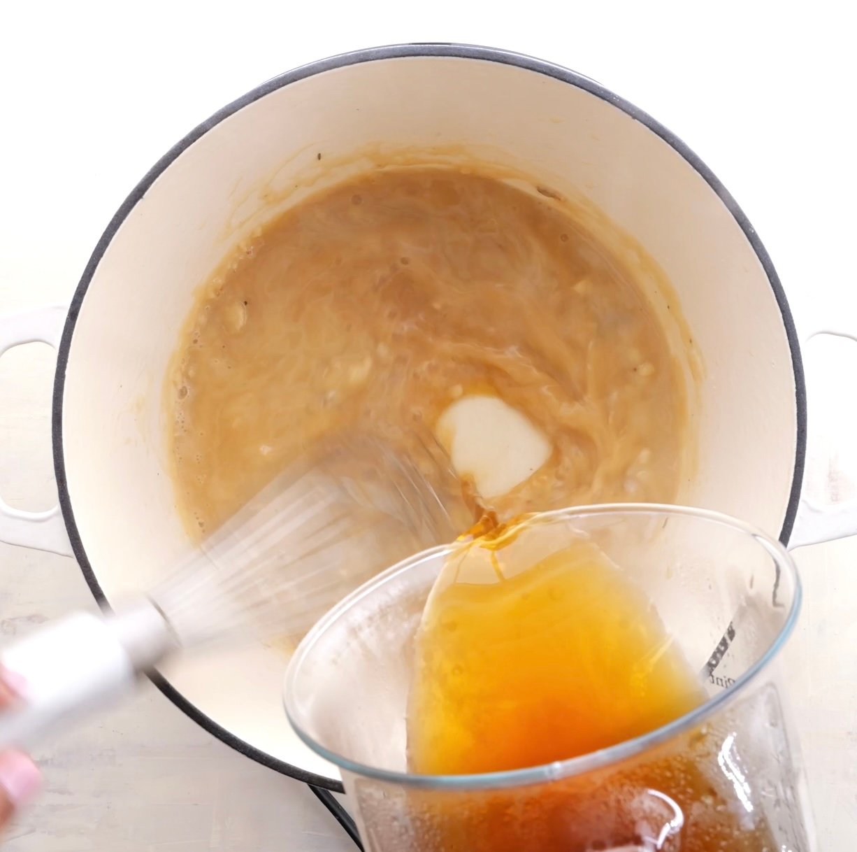 Beef broth going into a flour and oil roux for gravy.