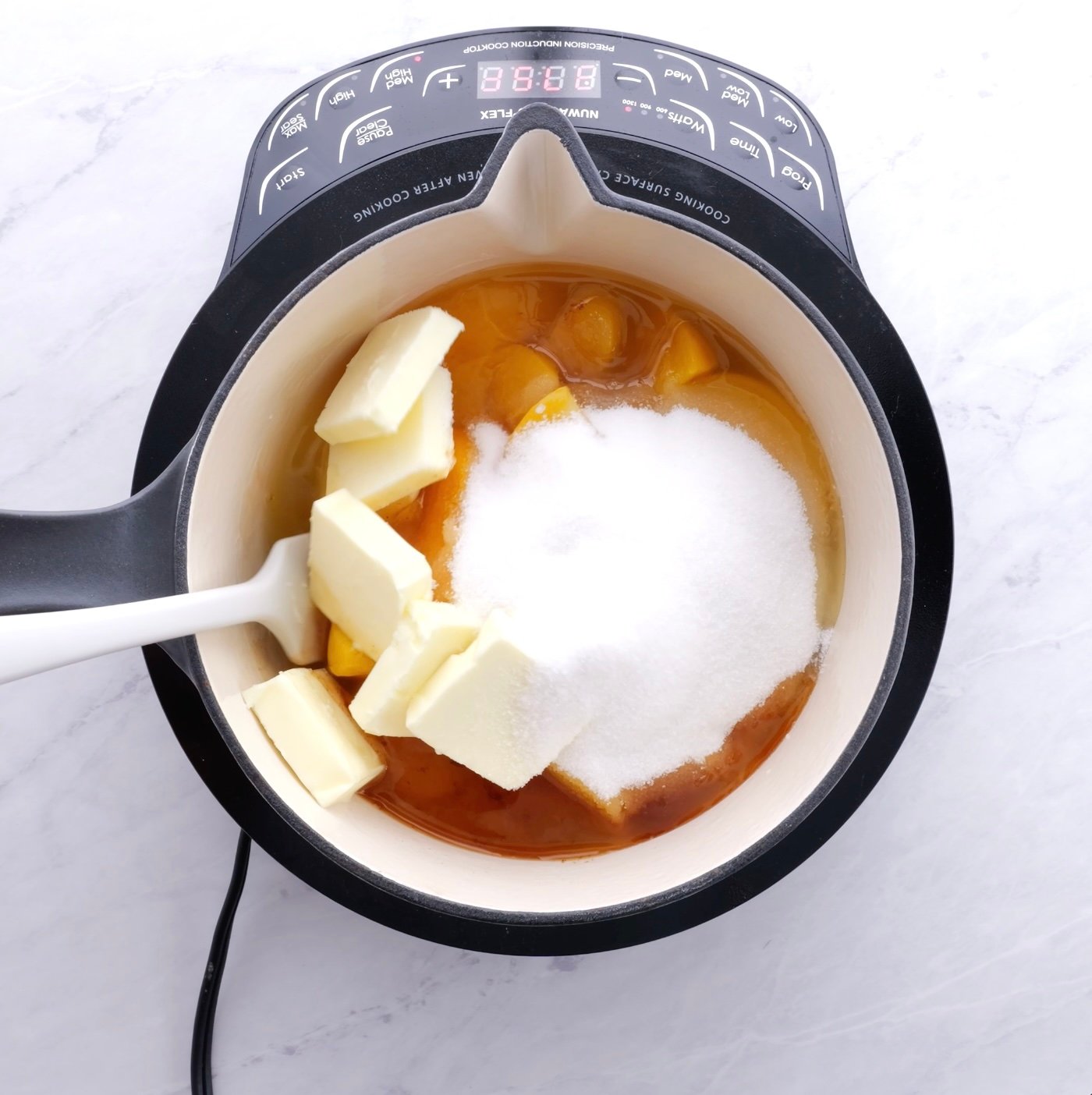 Heating canned peaches, vanilla, cinnamon, lemon juice, nutmeg, butter, sugar, and salt in a medium sized pot.