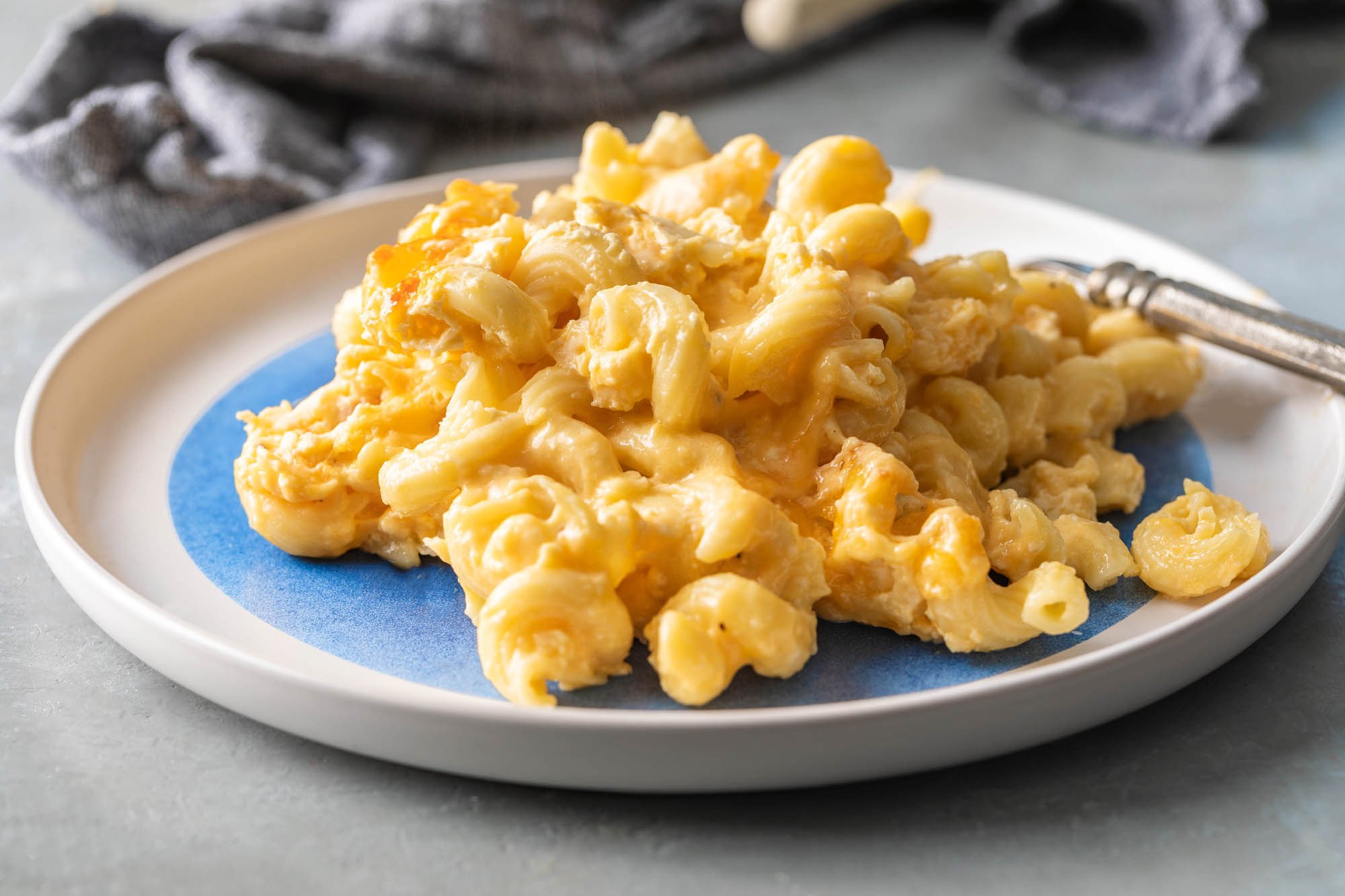 Mac and cheese on a blue and white plate.