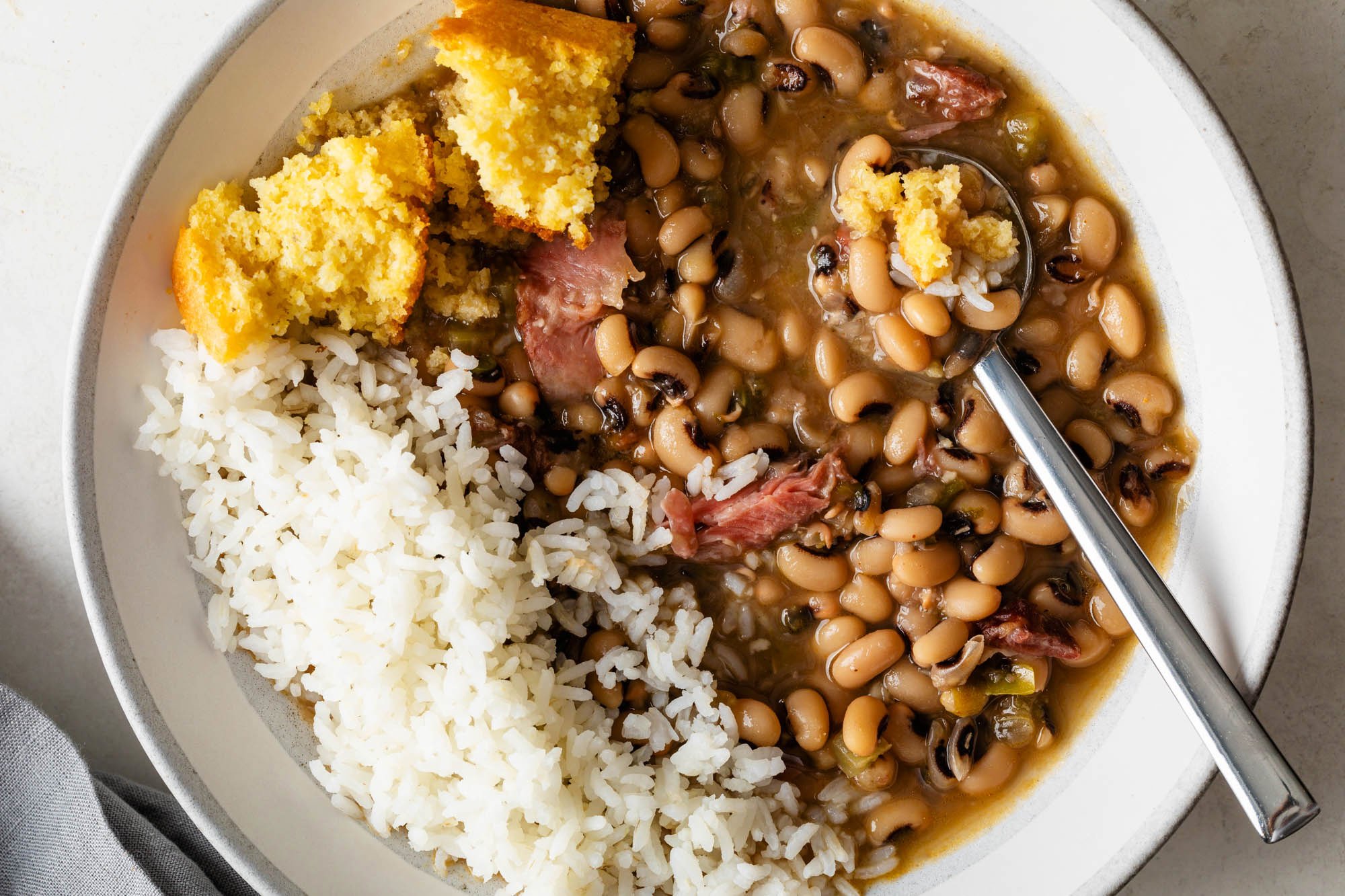 bowl of black eyed peas and rice with old-fashioned corn bread