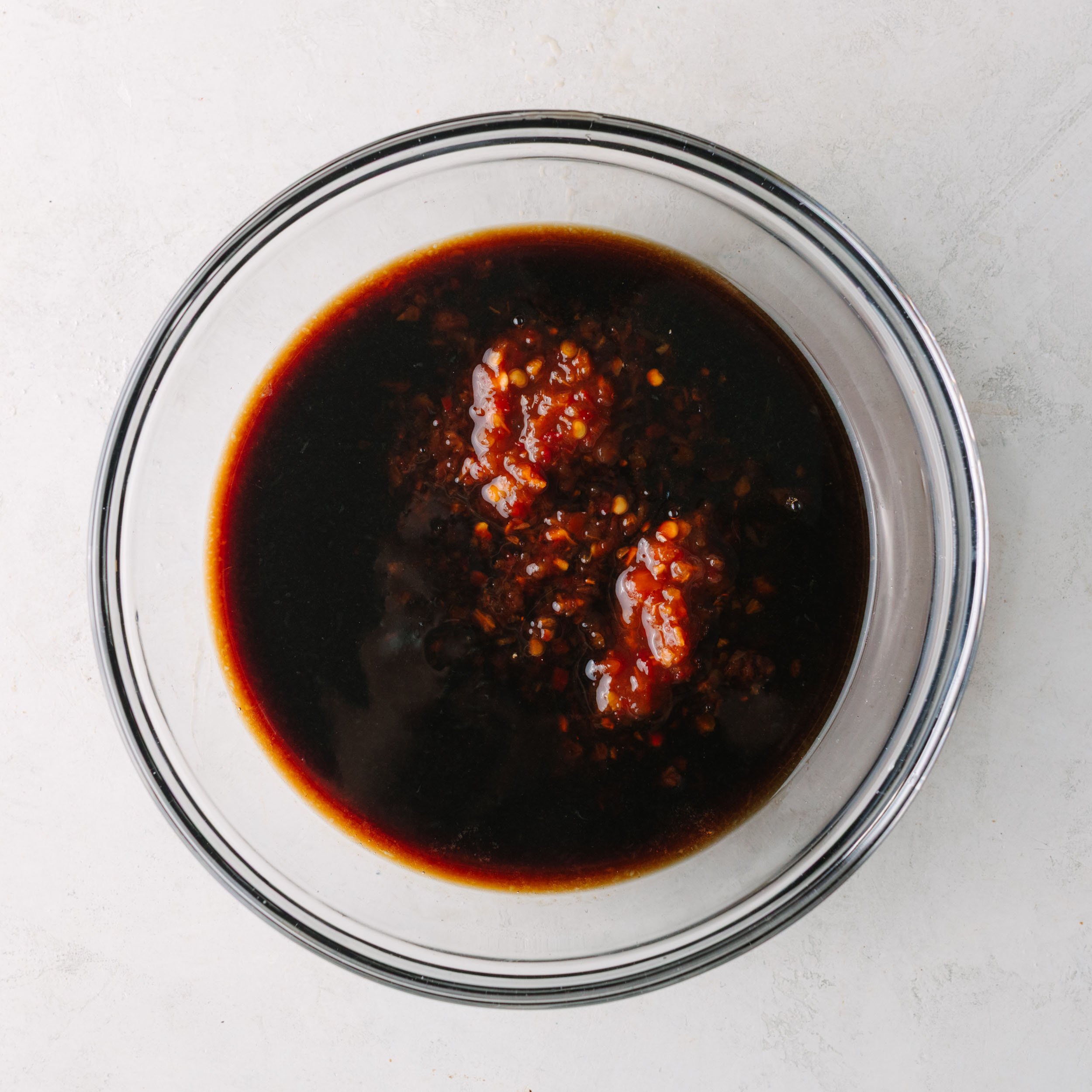 Asian wing sauce with chili garlic sauce being added.