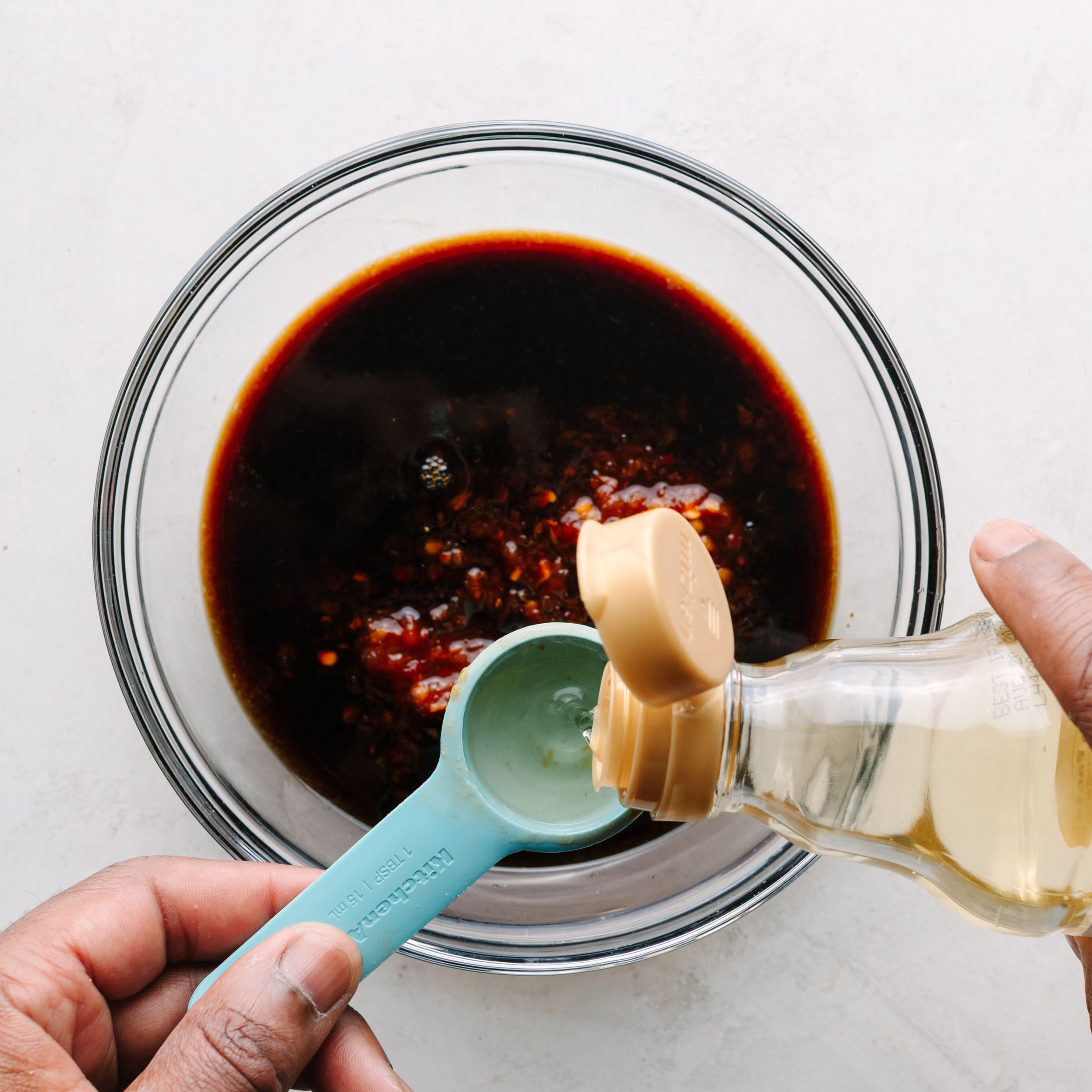 Asian wing sauce with rice wine vinegar being added.
