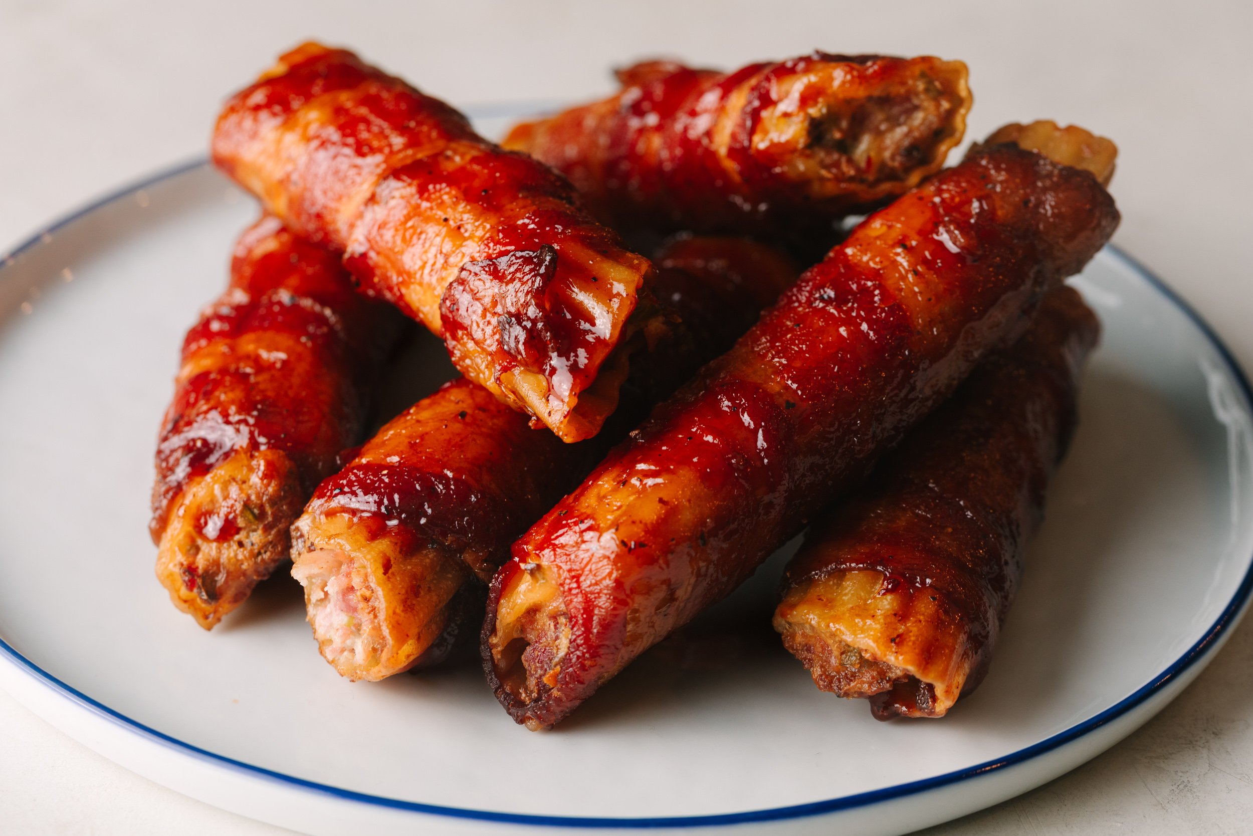Smoked pulled pork shotgun shells on a white plate.